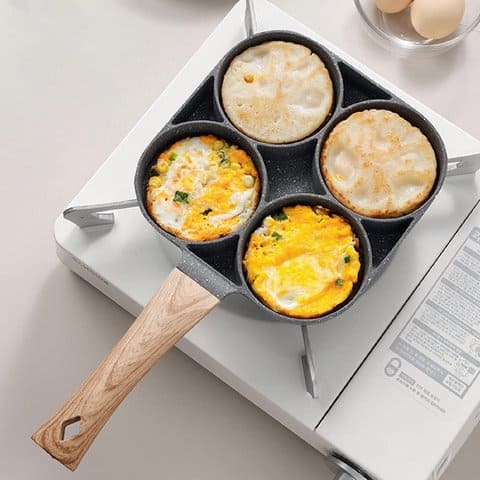 Sartén 4 puestos sobre cocina cocinando huevos y panqueques